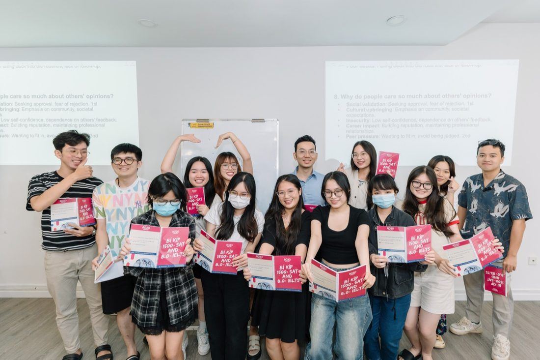 A large group of 8020 students and tutors holding handbooks